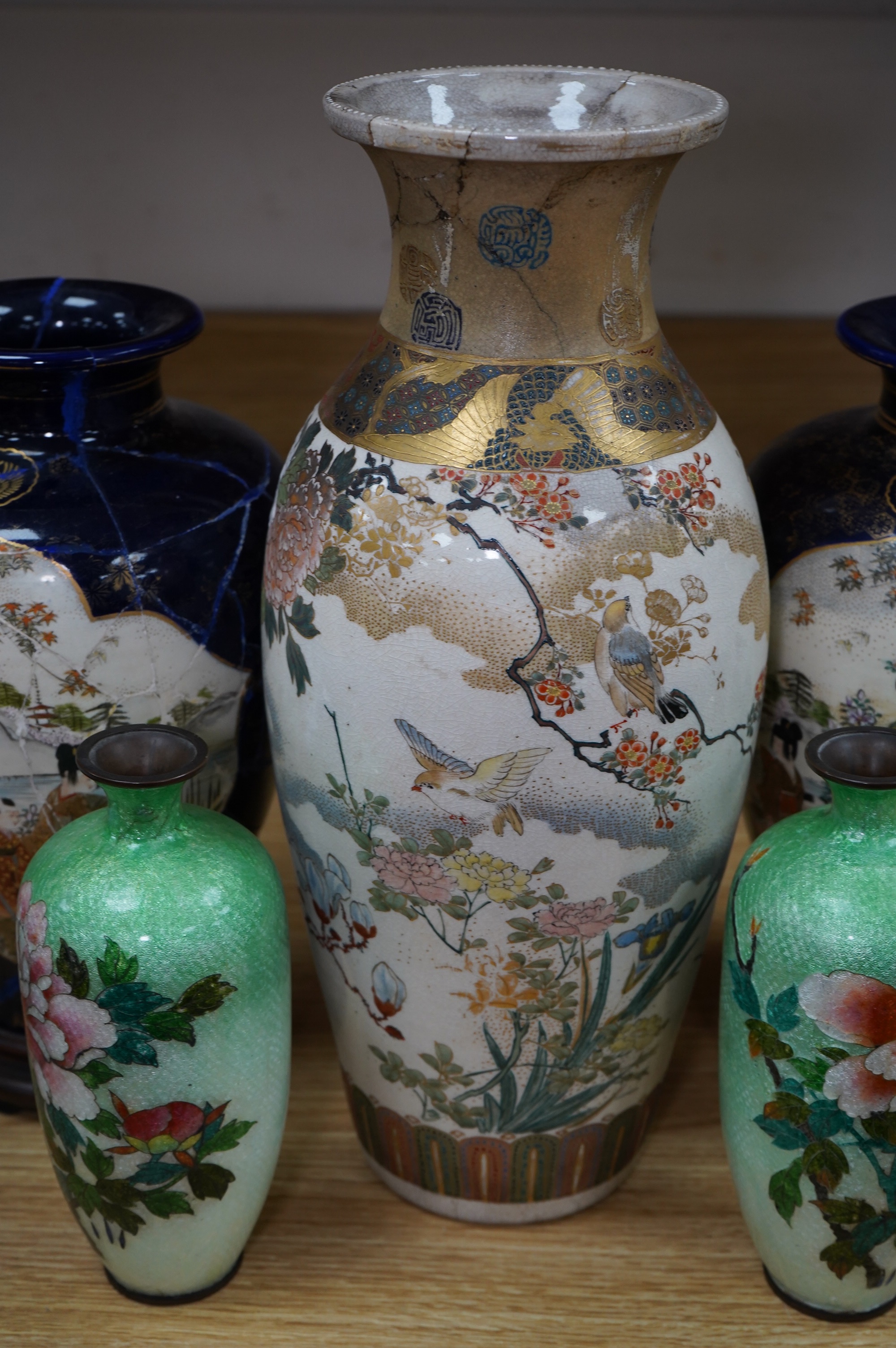 A pair of Japanese Satsuma vases on stands, a pair of floral enamel vases and another Satsuma pottery vase, largest 35cm high. Condition - poor